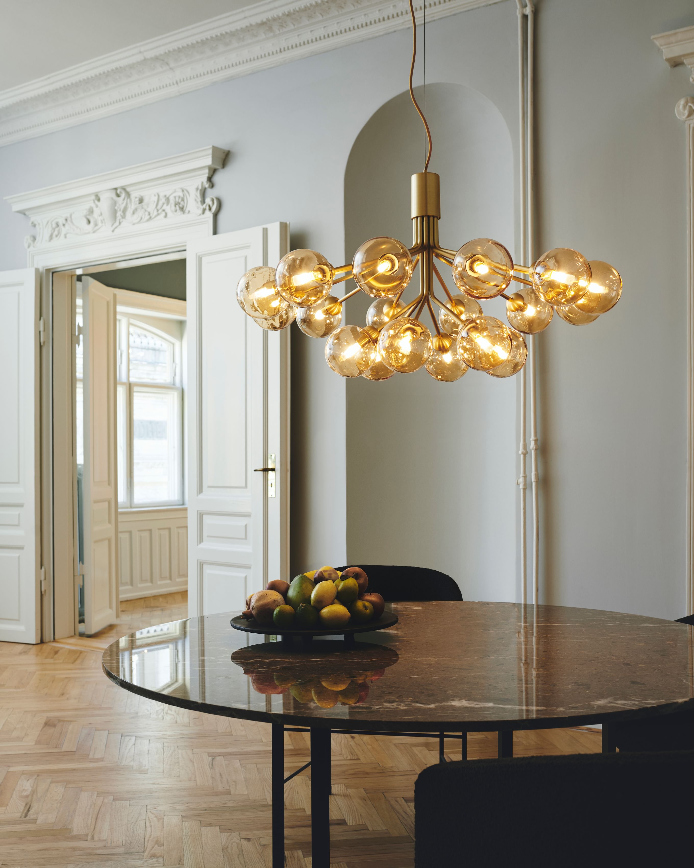 With inspiration from flowers, Sofie Refer designed the Apiales 18 chandelier. From a specially-produced canopy, the arms unfold like flower stalks from which light is spread with grace. 
