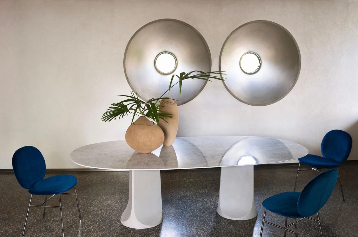 A totem with a sculptural base, a perfect synthesis of momentum, solidity, and craftsmanship. For Togrul, designer Gordon Guillaumier goes beyond the limits of matter by combining original finishes in a table suitable for both domestic environments and contract spaces. The rigid polyurethane bases, available in different sizes, are covered with hand-trowelled cementitious material for a tactile and visual experience.